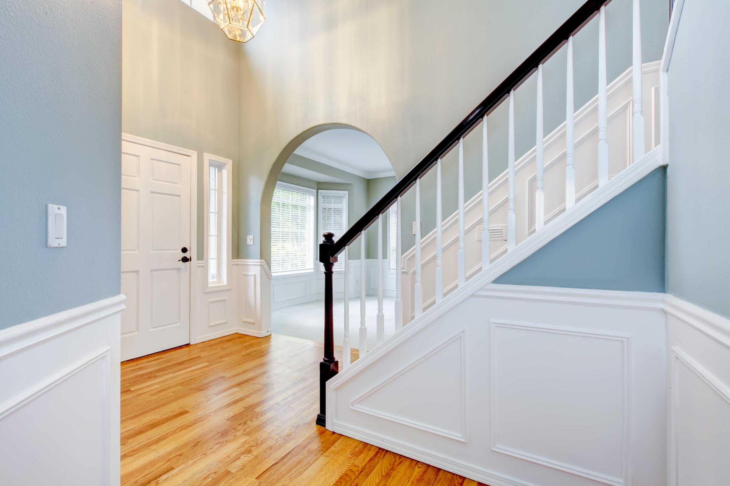 Blue luxury new entrace with white molding and staircase.